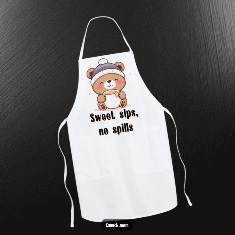 Funny apron showing a bear in a toque, delightedly sipping hot cocoa while cooking, adding kitchen humor.