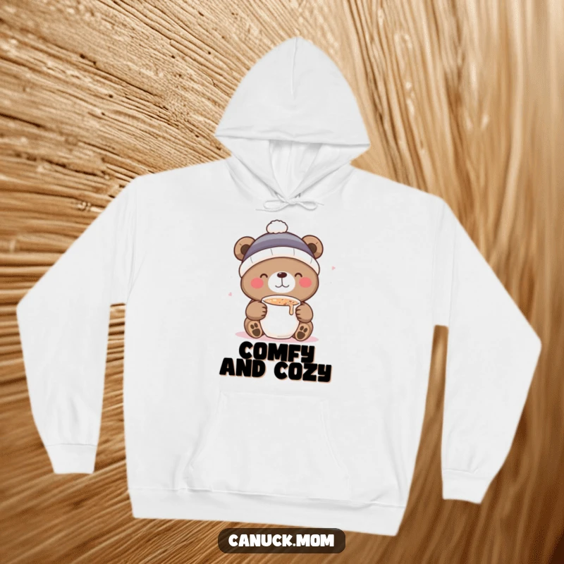 Funny hoodie with a delightful bear in a toque, sipping hot cocoa, offering warmth and a humorous winter vibe.