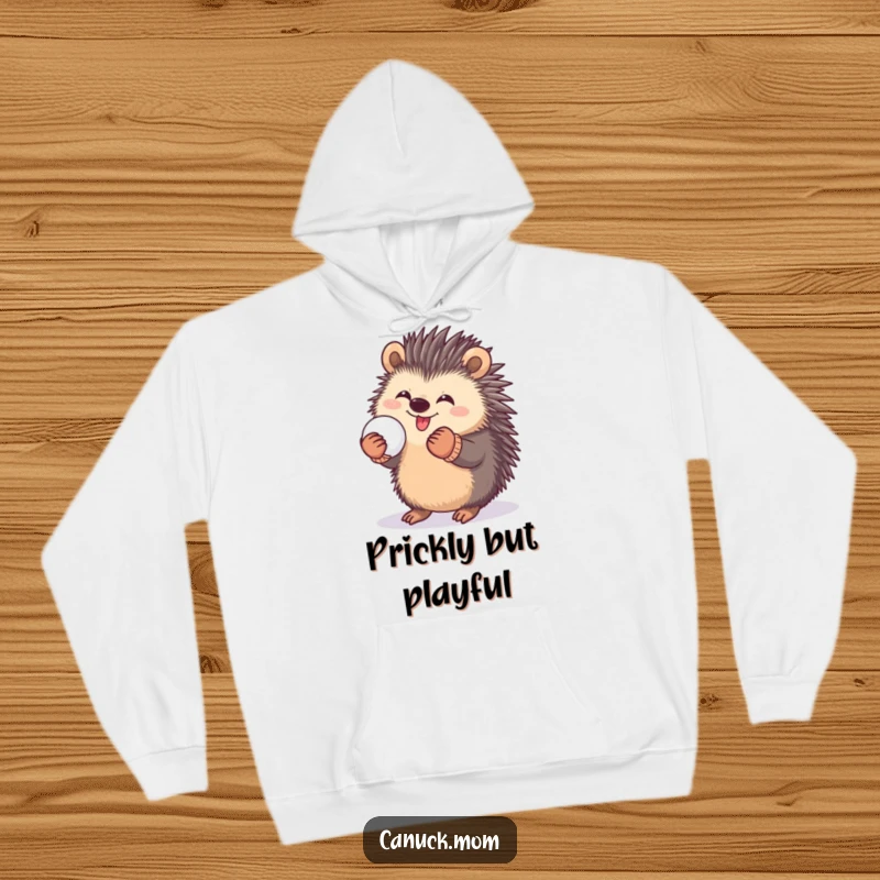 Funny hoodie featuring a happy porcupine in mittens, playfully holding a snowball, perfect for cozy winter activities.