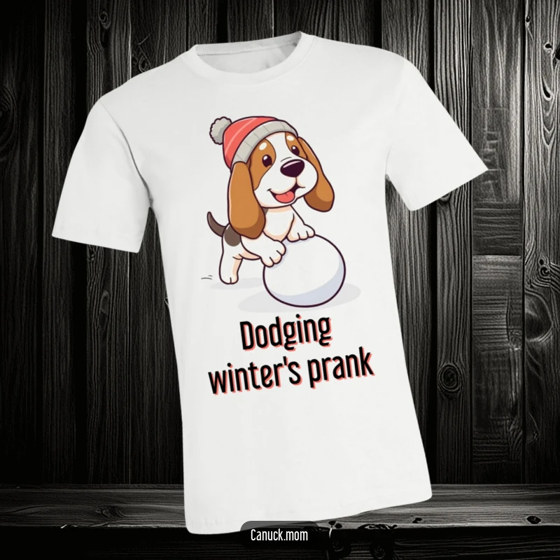 Funny Basset Hound T-Shirt: A dog wearing a hat trips over a rolling snowball, capturing a funny moment.